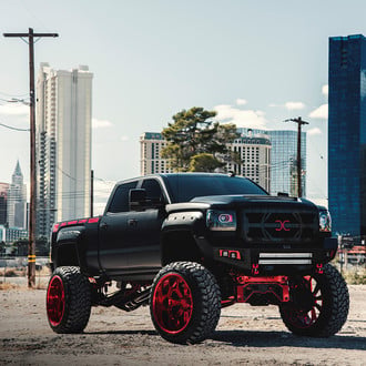 Black Lifted GMC Sierra with Aftermarket Headlights - Photo by Grid Off-Road