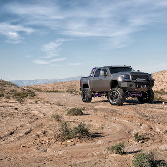 Gray Lifted GMC Sierra Sporting a Set of Gloss Black TIS Rims